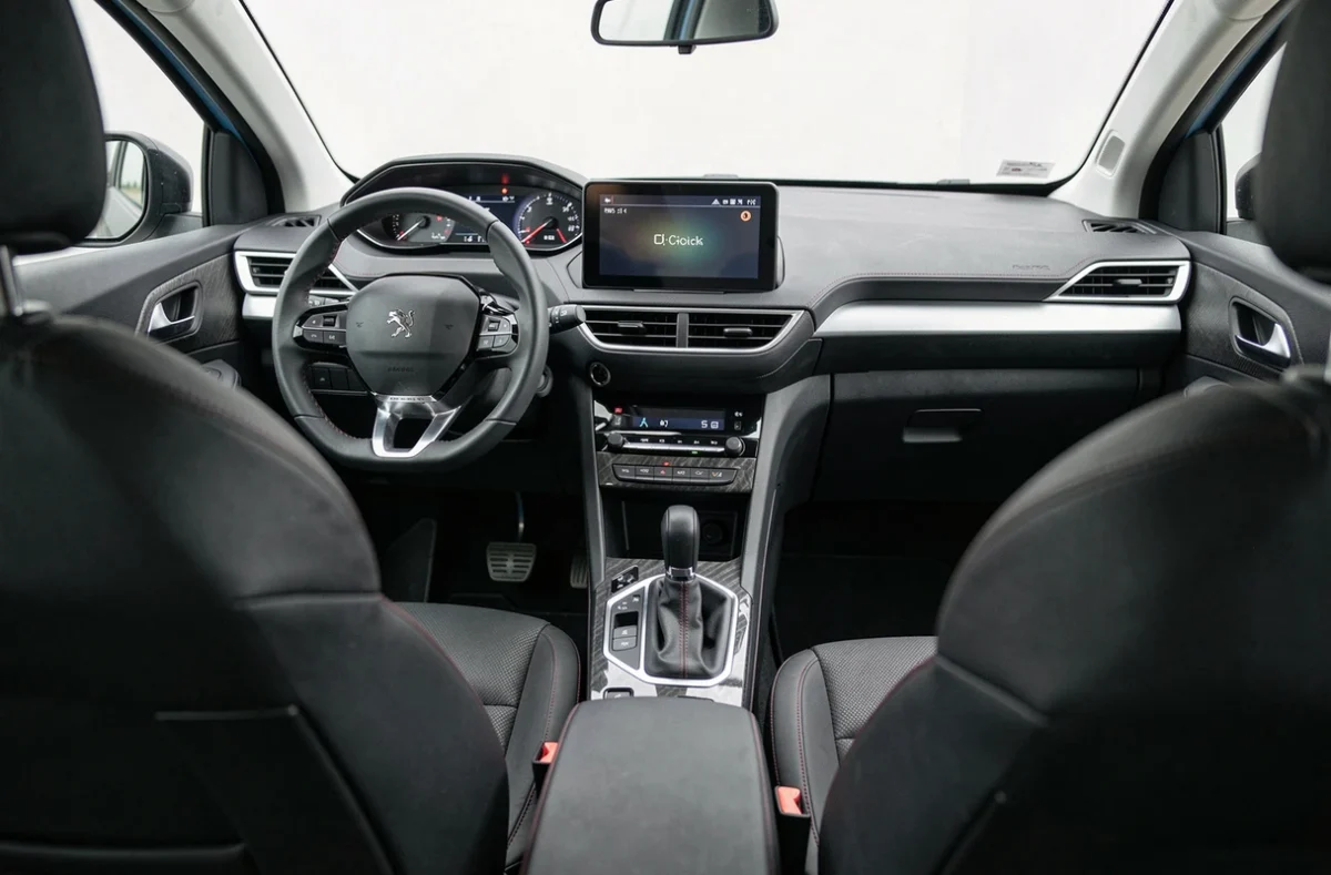 Intérieur de la Peugeot 2008 noire avec le tableau de bord i-Cockpit et les sièges en cuir noir couturés